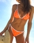 Corpiño bikini triangulo con breteles regulables y rellenos desmontables. Estampado a lunares color naranja fluo. Bikini Rock.