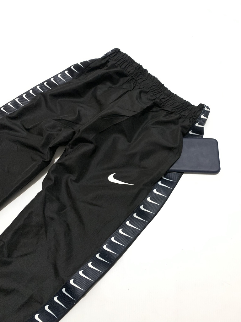 PANTALON NK ROMPEVIENTO UNLIMITED LOGO TOTAL BLACK