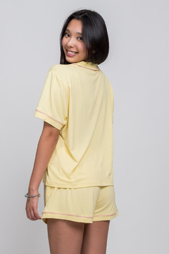 modelo veste conjunto de pijama super confortável na cor amarelo com detalhes em rosa
