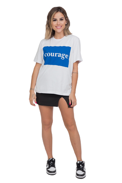 modelo veste blusa t shirt branca básica com estampa azul, escrito courage