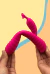 Mão segurando vibrador rabbit Ola na cor rosa com estímulo duplo, mostrando sua maleabilidade em 360 graus