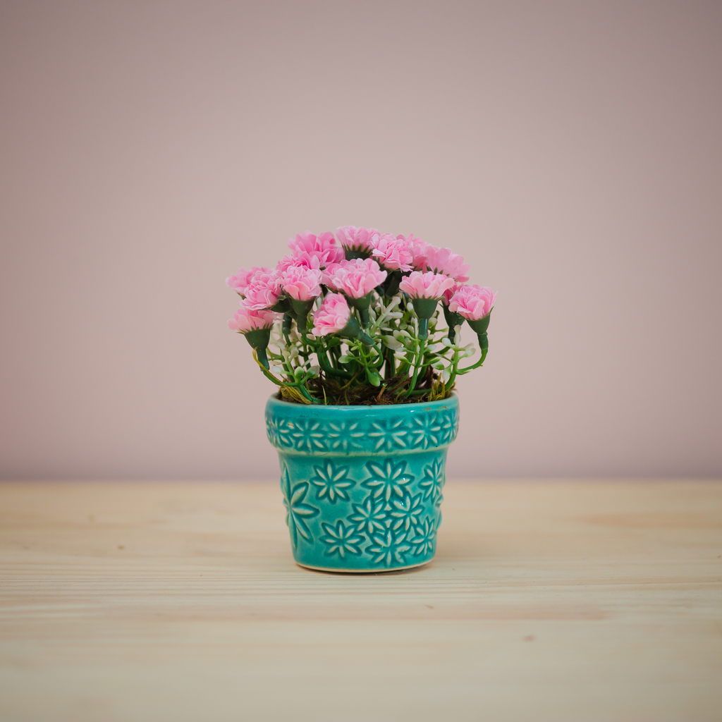 Vaso azul turquesa com arranjo de flores artificiais rosa
