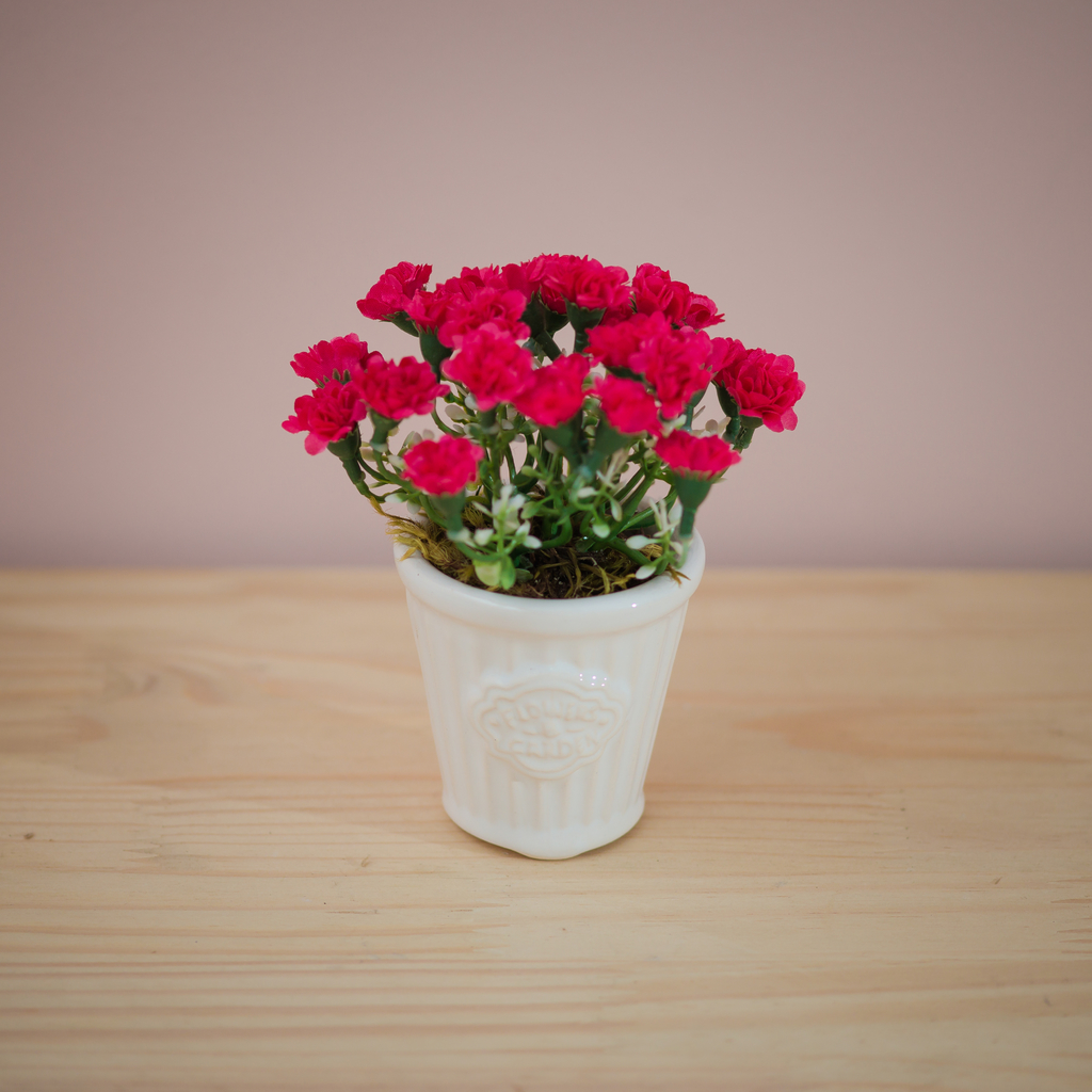 Vaso branco com arranjo de flores artificiais vermelhas