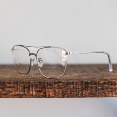 anteojos armazones para colocar lentes de aumento hechos en metal color plata brillo satinado de forma rectangular con puente y barral modelo La Juanita marca Nómade vista perfil izquierdo