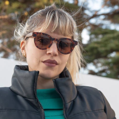 Mujer luciendo anteojos de madera (patillas) y acetato (frente) color carey de forma redondeada con lentes de sol polarizados modelo Chalten marca Nómade (vista de frente)