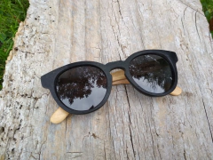 anteojos de madera (patillas) y acetato (frente) color negro de forma redondeada con lentes de sol polarizados modelo Chalten marca Nómade (vista de frente)