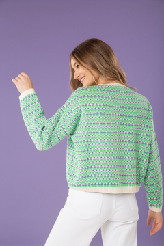 Buzo en hilo de lana tejida con punto fino. Cuello a la base y diseño en color verde combinado con crudo.