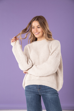 Sweater en hilo de lana con punto grueso que le da una caída ideal. Tiene terminación de puño y cuello redondo. En color crudo.